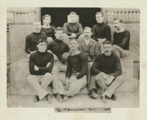 James Naismith (wearing suit) poses with members of the 1892 Springfield College Secretarial Basketball team. This team is sometimes referred to as the first basketball team in existence. (Photo via Springfield College Archives and Special Collections)