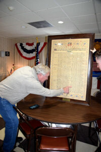 Bob Lord and Matty Sargent find the line for Ralph J. Lord, listing his birth and death, on a recently rediscovered calligraphy piece that notes local World War I service histories.