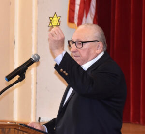 Israel Arbeiter holds up a “Jude” badge, a star of David that Jewish people were forced to wear under the Nazi regime. “Jude” is German for Jew. Photo/Courtesy of Friends of March of the Living