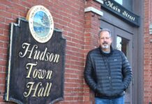 Paul Tucker with his signage at Hudson Town Hall.