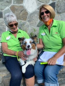 Normandy Farms employee Cindy Fuller and work camper Elaine Armstrong welcome a canine guest. Photo/Submitted