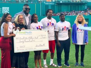 CEO & Founder Pooja Ika presenting $70,000.00 to the David Ortiz Childrens Fund on David Ortiz Day at Fenway Park
