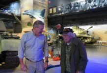 Hunter Cheney, left, director of marketing and communication for the American Heritage Museum in Hudson, escorts 101-year-old WWII veteran Russell Phipps.