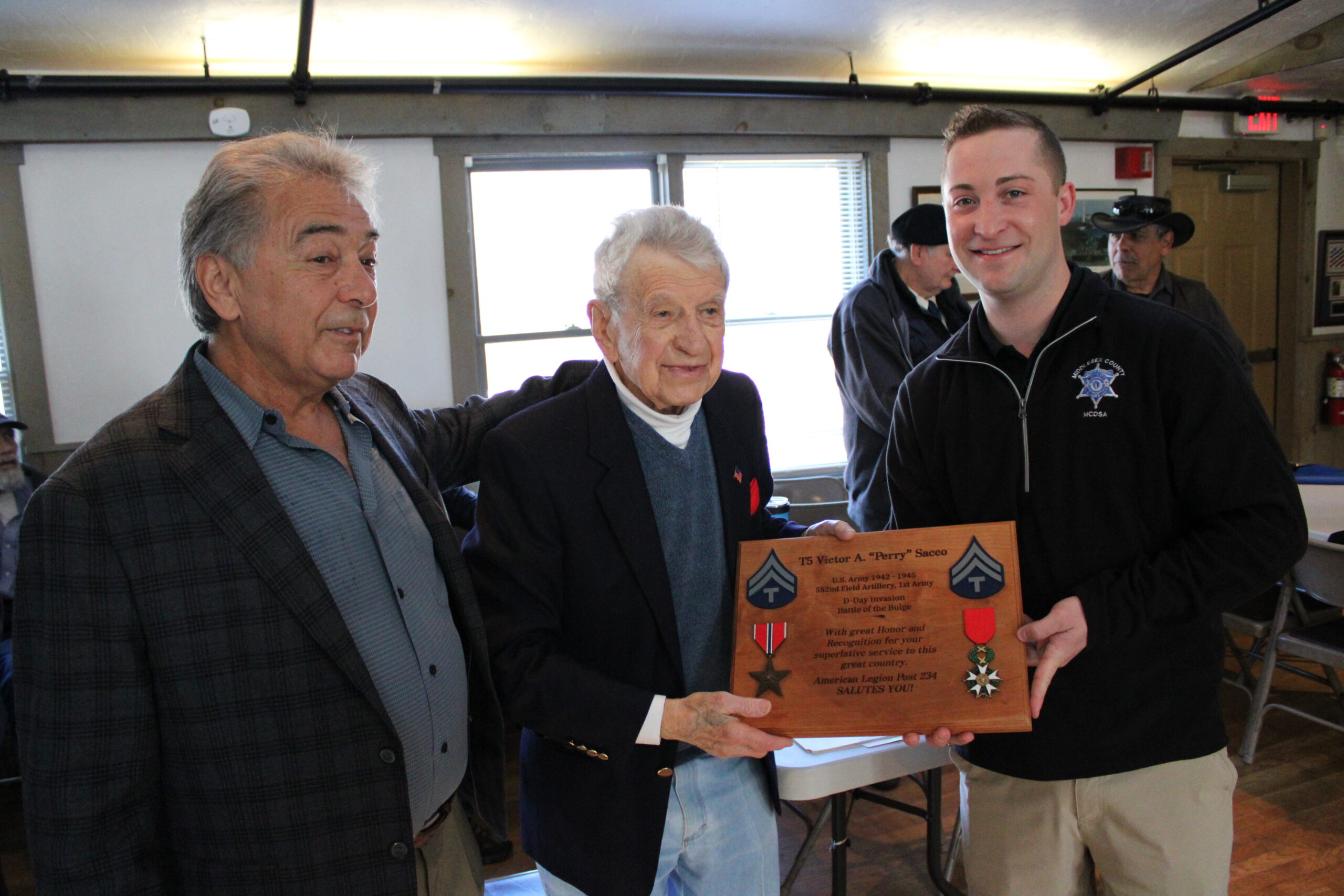 Victor A. “Perry” Sacco, center, receives a plaque commemorating his service in WWII during a ceremony at the American Legion Vincent F. Picard Post 234 on April 2. Flanking him are former post commander Roger Langevin, left, and the post’s vice commander, Spencer Jacobs. Photo/Maureen Sullivan