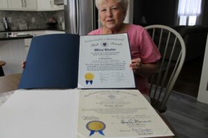 Wendy Mickel shows the two citations presented to her as a Commonwealth Heroine.Photo by Maureen Sullivan
