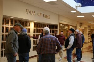 Algonquin Athletic Director Mike Mocerino guides the championship-winning 1973 football team around the school as part of an extended tour. (Photo/Evan Walsh)