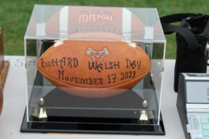 Richard ‘Dick’ Walsh receives this commemorative football by Algonquin Athletic Director Mike Mocerino to honor his dedication to the school’s athletic program. (Photo/Evan Walsh)