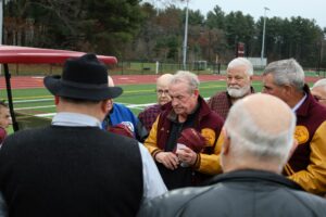 The championship-winning 1973 football team members remove their caps to remember and honor teammates and coaches who have since died. (Photo/Evan Walsh)