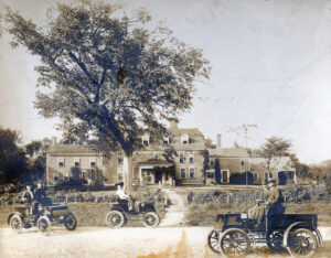 The Wayside Inn in Sudbury, shown here in 1904 with electric cars passing by, underwent numerous improvements in the early 20th century.