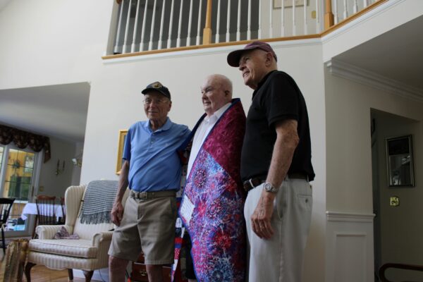 Daniel E. Brogie, center, is presented a Quilt of Valor from members of the Westborough Veterans Advisory Board on Tuesday, July 16, in Brogie’s home.