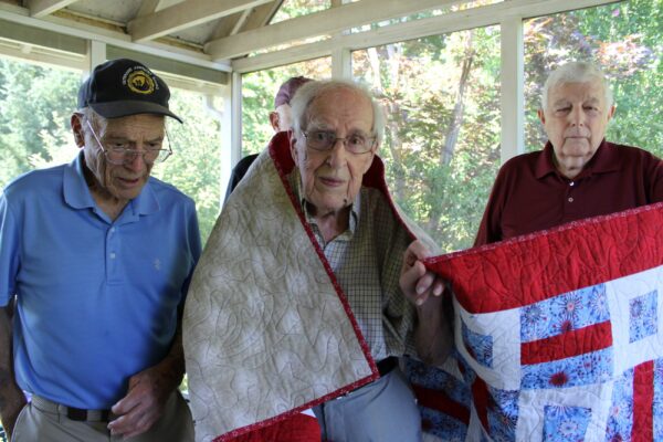 Earl Wood, center, is presented with a Quilt of Valor on Tuesday, July 16, in his home.