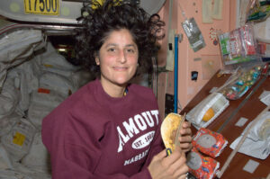 Needham native and astronaut Sunita Williams prepares a snack on the International Space Station, wearing a Falmouth, Massachusetts sweatshirt. Photo: Courtesy of NASA