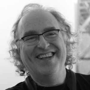 Russ Gershon, founder of the Either/Orchestra, smiling and wearing glasses.