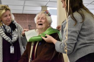 Bunny Perron, 104, smiling and receiving a Boston Post Cane pin at Westborough Senior Center
