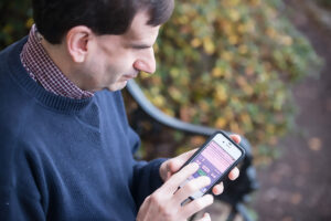 Man using smartphone accessing digital books at Worcester Public Library