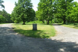 Abandoned town of Dana, Massachusetts, overgrown road and stone marker.