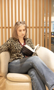 Christina Inge, digital strategist, reading a book illustrating storytelling and marketing education in Westborough, MA.