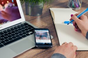 Digital estate planning with laptop, smartphone, and notebook.
