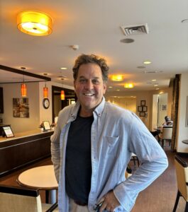Glenn Cort, author and former lawyer, smiling in a restaurant setting