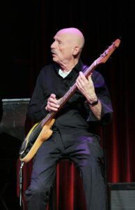 Tony Levin playing bass guitar on stage, musician and Chapman Stick player.
