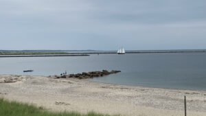 First Beach in Sandwich, Massachusetts, and a sailboat on the water.