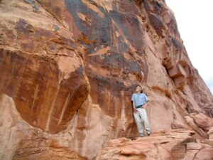 Evan Hadingham examining ancient rock art and prehistoric archaeological site.