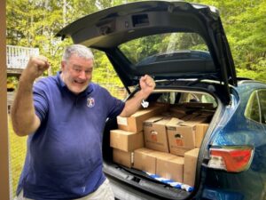 Jim Hurley with boxes of personal hygiene products for 4Others Inc. in Westborough, MA.