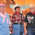 (l to r) Linda Johnson, Cynthia Stroschein and Dotty Clark sing “You Can’t Get a Man with a Gun.”