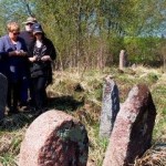 Family members on an Ancestral Footsteps tour pay their respects at the grave of a great great grandfather.